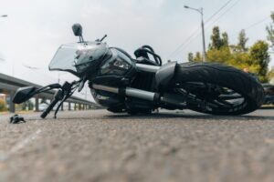 A damaged motorcycle lies on the road after a severe collision. A motorcycle accident lawyer can tell you more about what to do after a motorcycle accident to protect your rights.