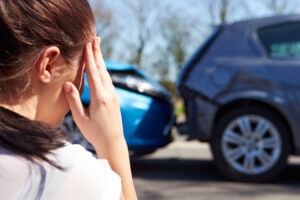 A woman touches her head to stop the nausea after a car accident. Nausea and vomiting after a car accident means that she has to get immediate medical attention.